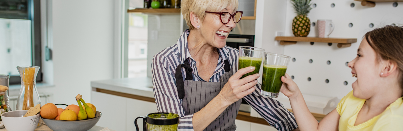 A grandmother drinking a smoothie with her granddaughter