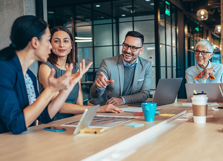 A group of employees talking around a conference table