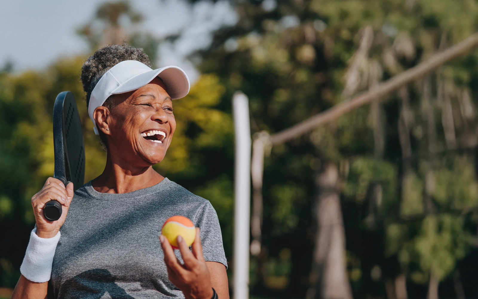 woman-smiling-while-playing-tennis-1600x1000.webp