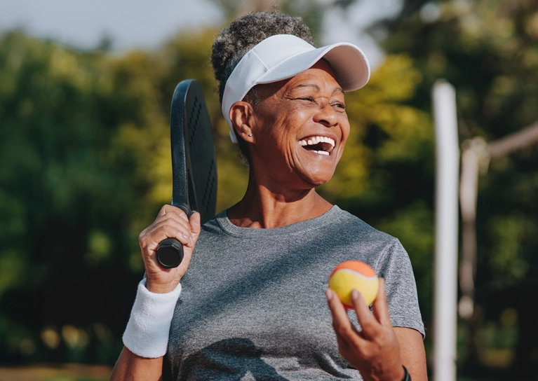 woman-smiling-while-playing-tennis-767x544.webp