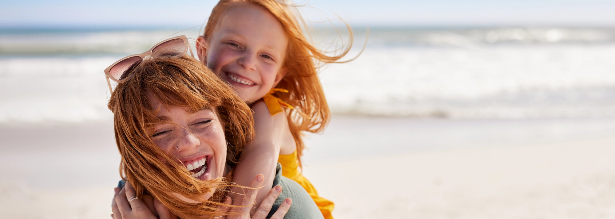 mother_and_child_laughing_at_beach_2000x714.webp