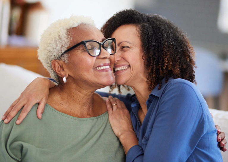 older_women_hugging_and_smiling_767x544.webp
