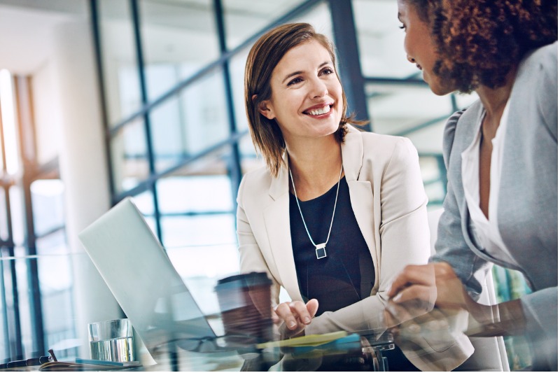 A broker talking with a client at a desk