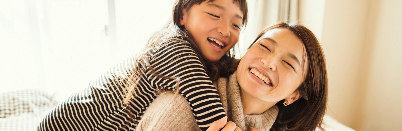 A mother and daughter smiling