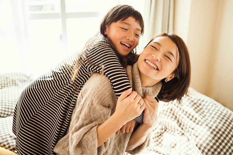 A mother and daughter smiling