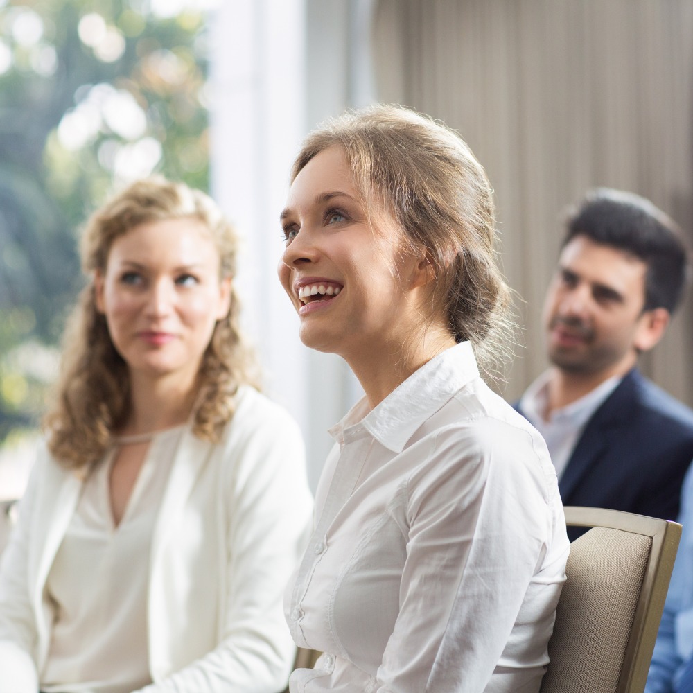 smiling-audience-watching-presentation-picture-1000x1000.jpg