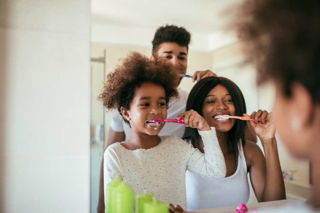 A family brushing their teeth together