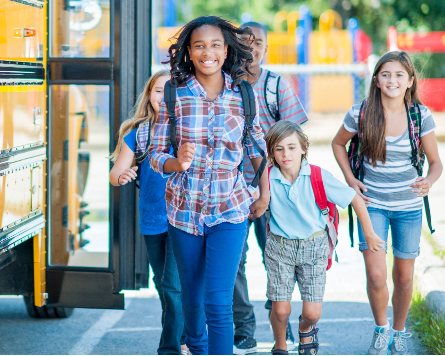 A group of students walking beside a bus