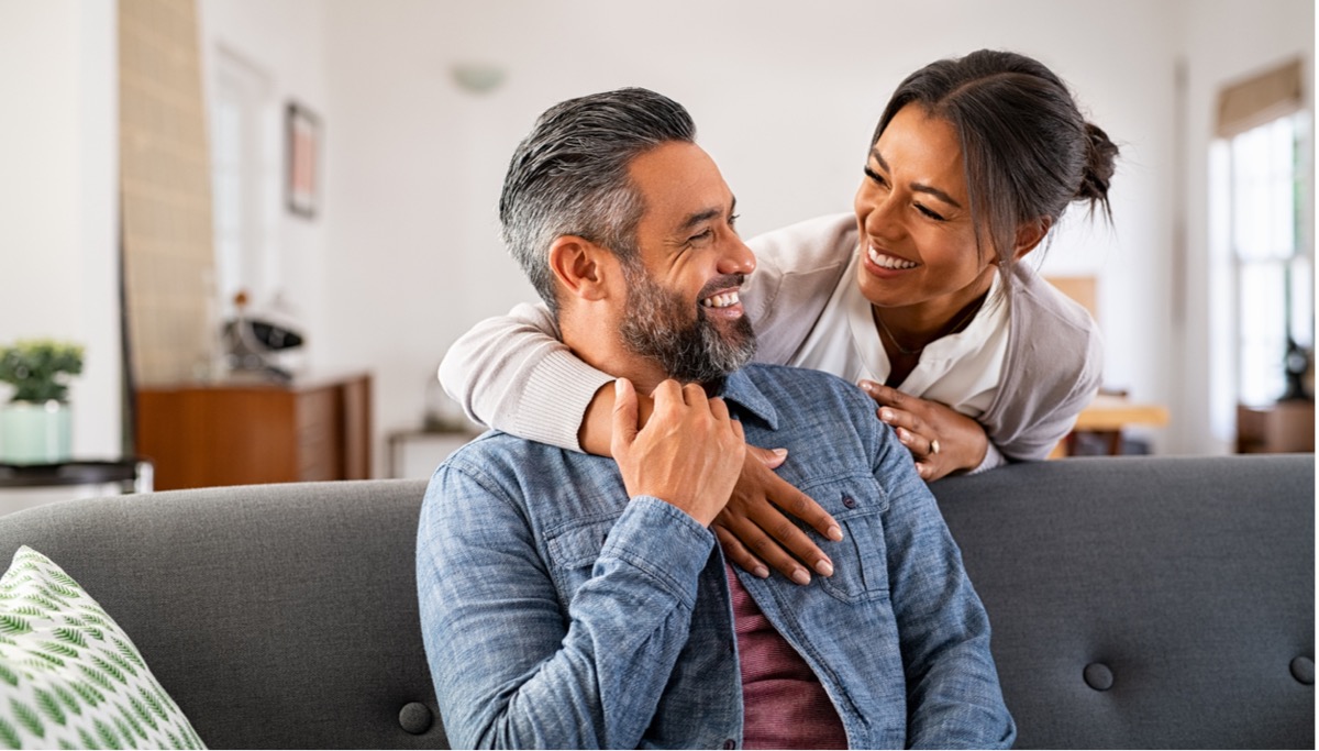 mature-multiethnic-couple-laughing-and-embracing-at-home-picture-1200x683.jpg