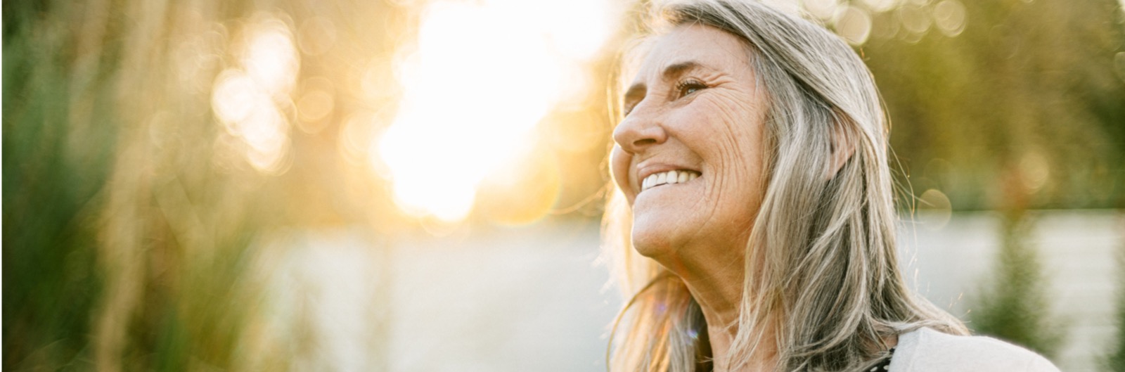 A woman smiling outside in the sun