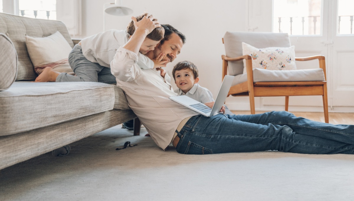A father and two children playing in a living room