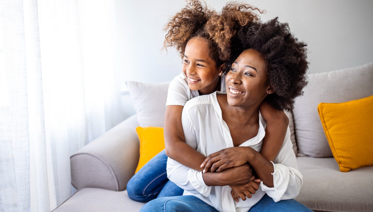 A mother and daughter smiling and hugging