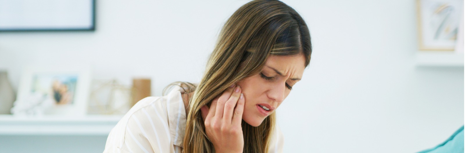 A woman holding her jaw in pain