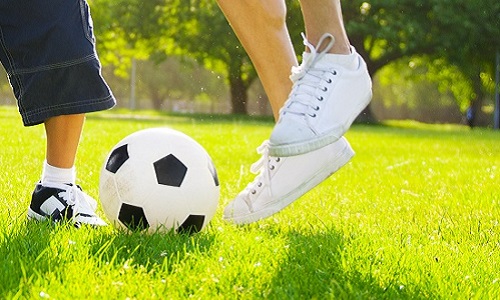 Little Boy Playing Soccer With His Father